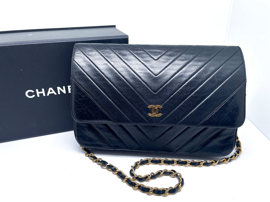 Chanel Wallet on Chain handbag in black lamb leather and chevron pattern.