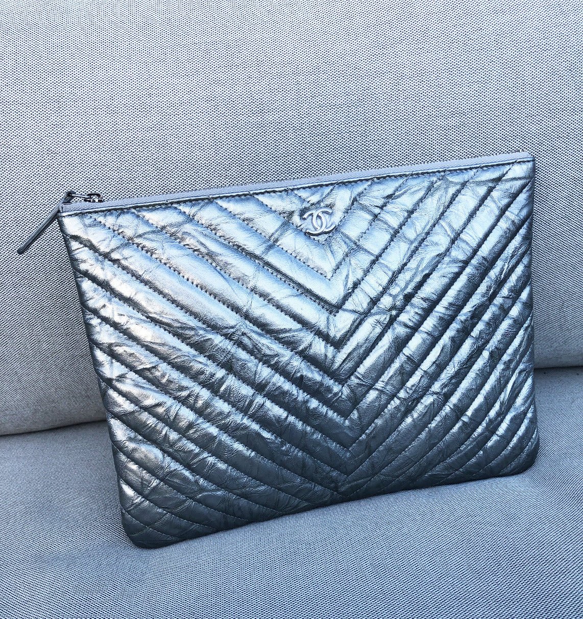 Clutch Chanel pochette O case en cuir de veau métallisé argenté chevron - Soline